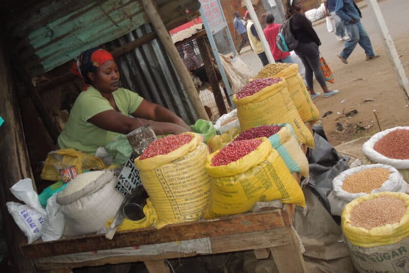 Woman preparing foodstuffs at a market stand.