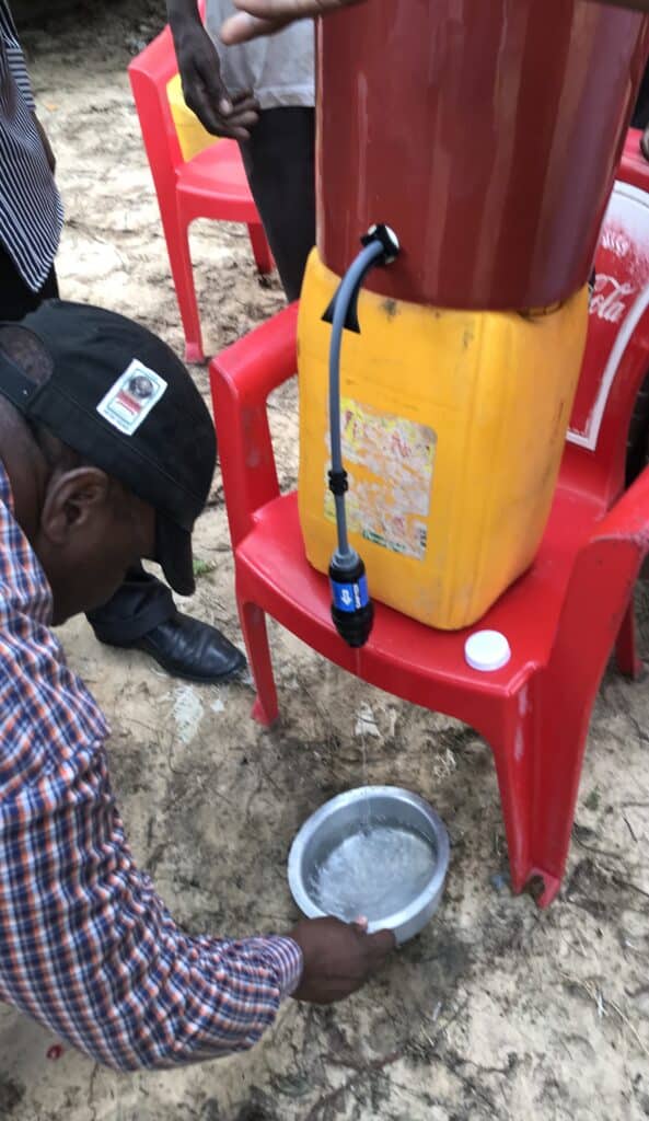 A man outside getting filtered water.