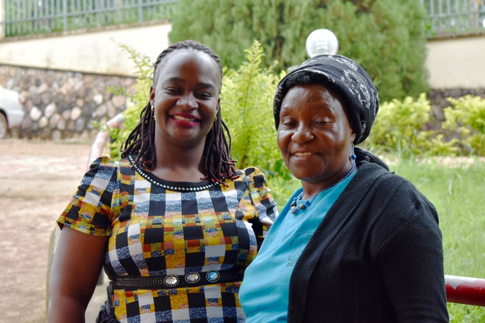 Two women standing outside smiling.