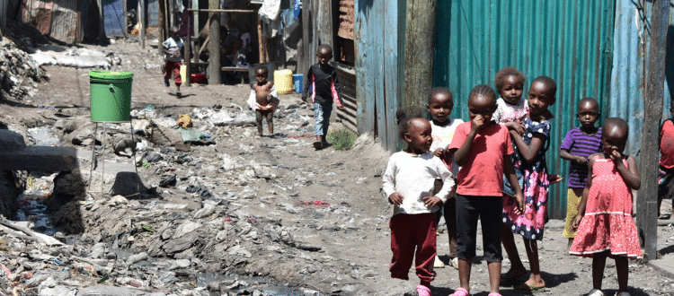 Group of young children walking outside in an impoverished area.