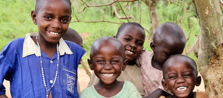 Group of children outside smiling.
