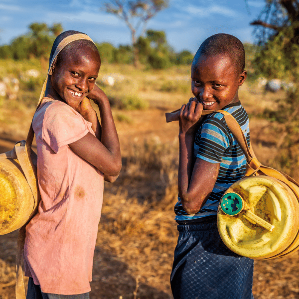 Two children smiling outside.