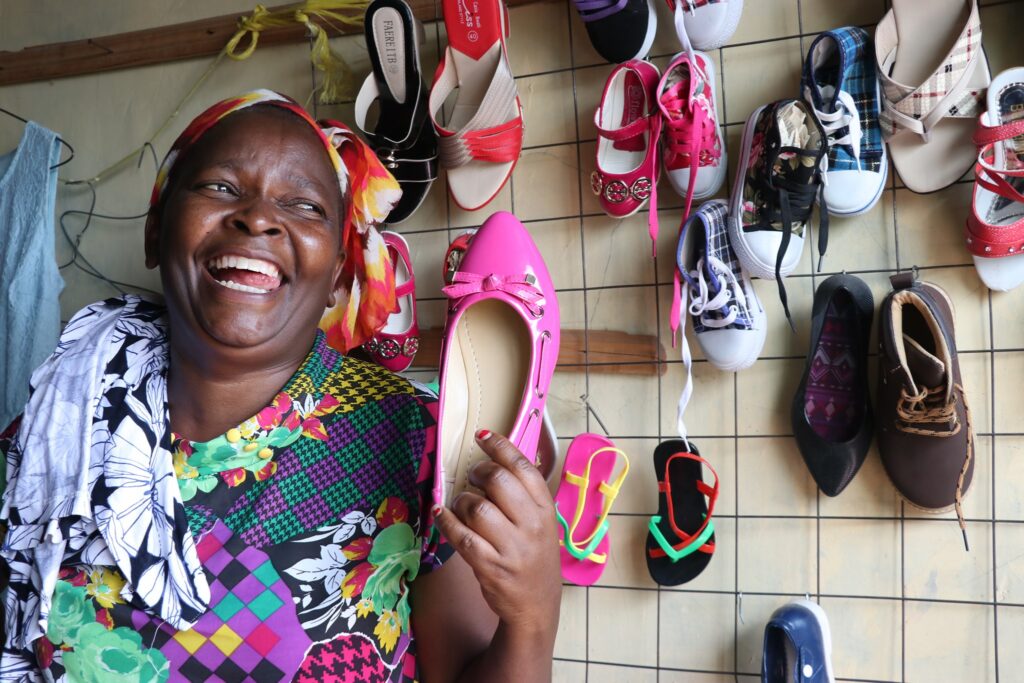 Woman working in shoe shop and laughing.