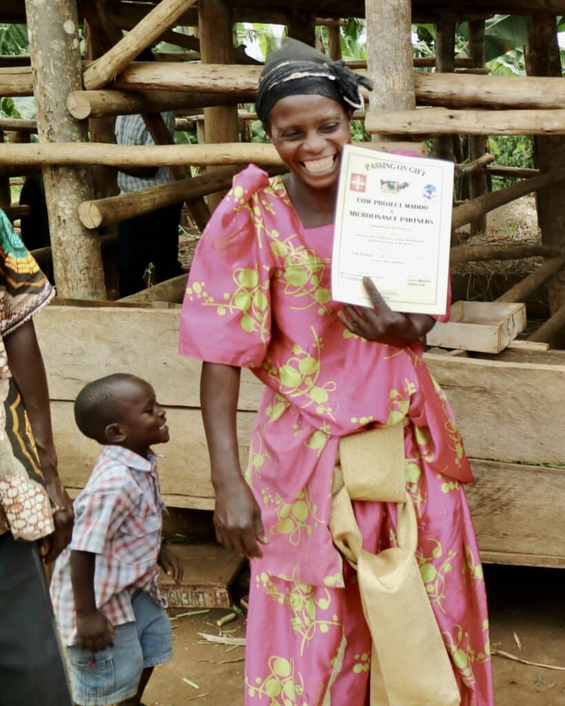 A woman outside smiling with her child.