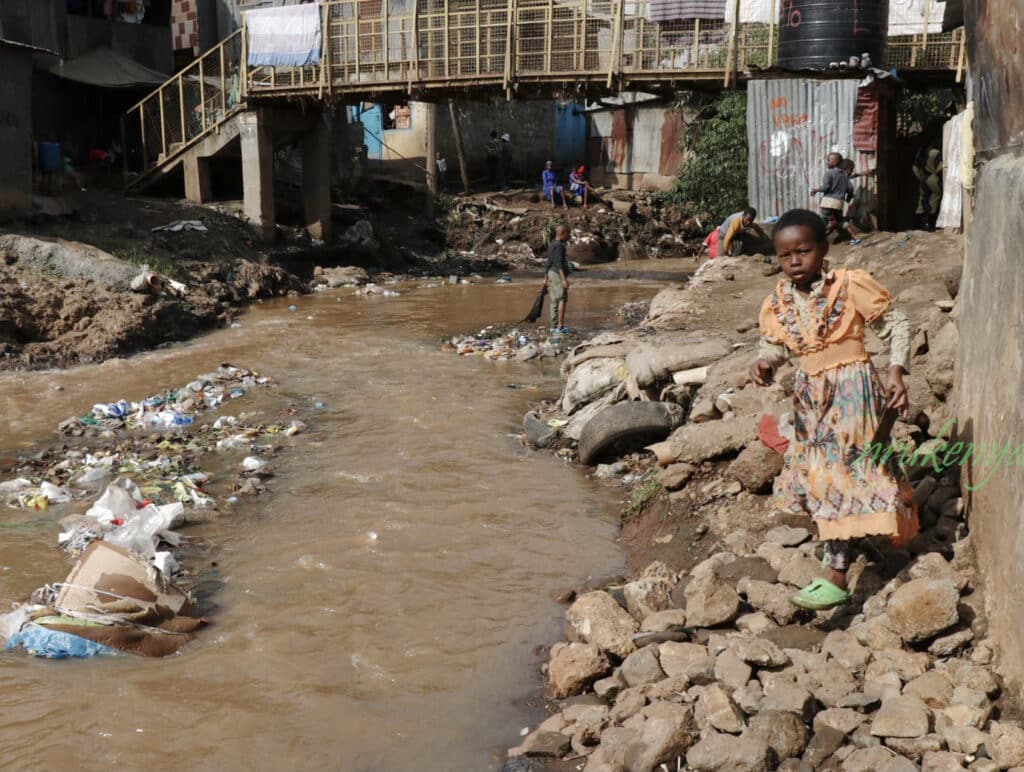 Dirty water runs down the road of an impoverished town.