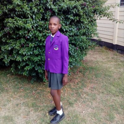 Cynthia - Shalom standing outside wearing her school uniform.
