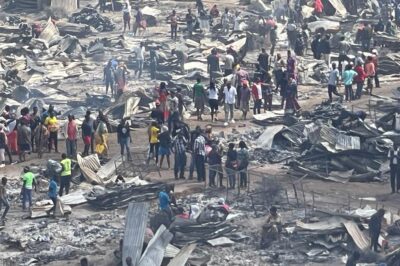 Large numbers of people looking through damage of the fire in Kibera Slum.