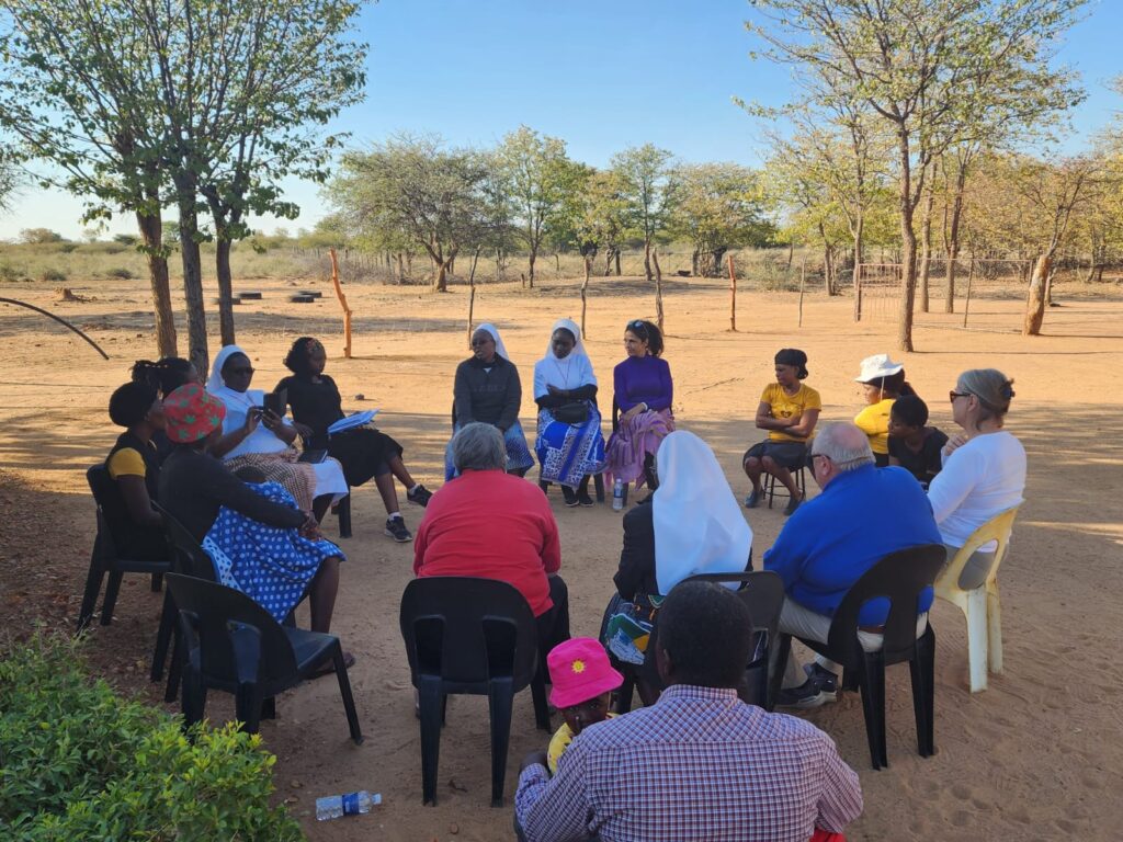 A group of people sitting outdoors in a circle.