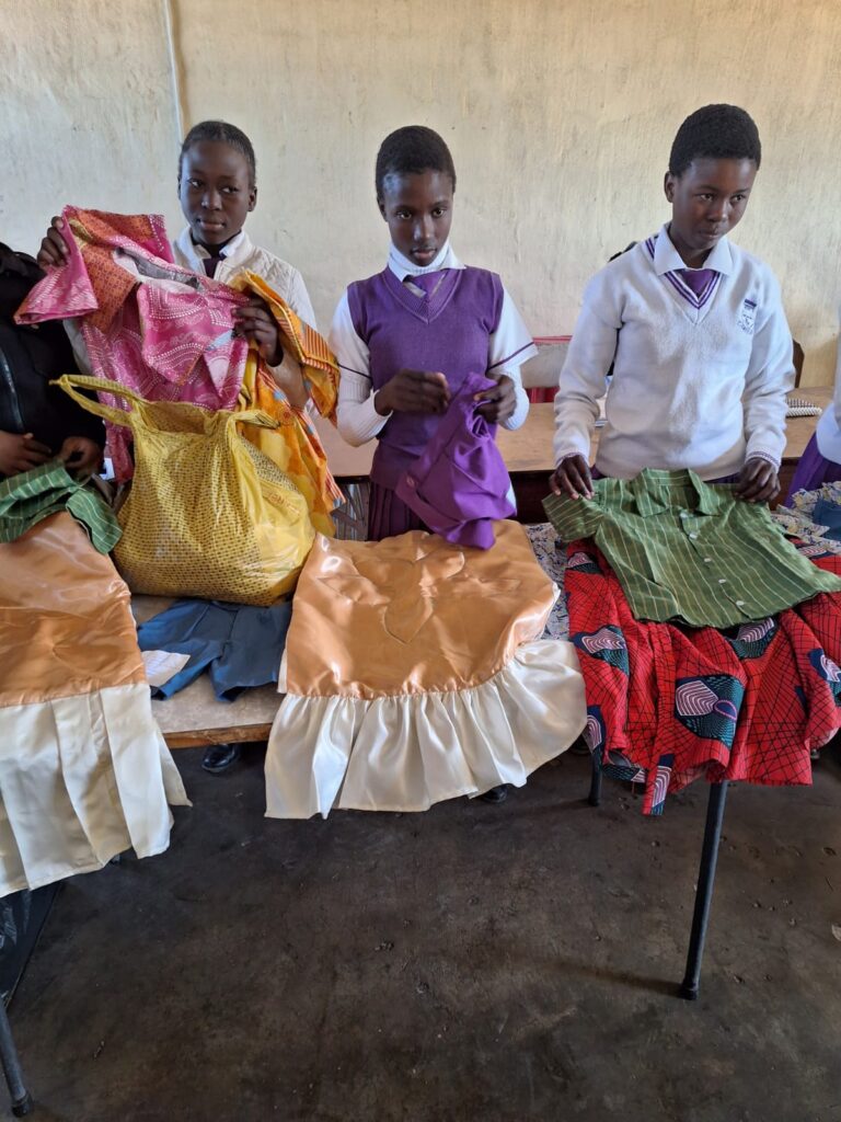 Three young people holding clothes.