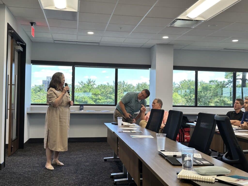 A group of people listening to a presentation in a conference room.